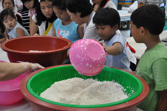 ▲떡을 만들기 위해 불린 쌀을 옮기고 있다. 