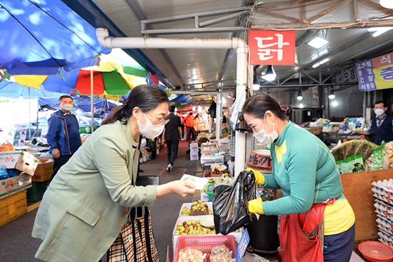 ▲은수미 성남시장이 전통시장에서 지역상품권으로 물건값을 치르고 있다